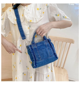 Lifestyle shot of a blue denim mini crossbody bag worn with a floral dress