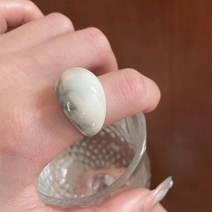 Macro detail of dopamine marble resin ring in milky white with elegant grey texture