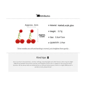 Detailed view of cherry pendant earrings with pom poms and silver needles