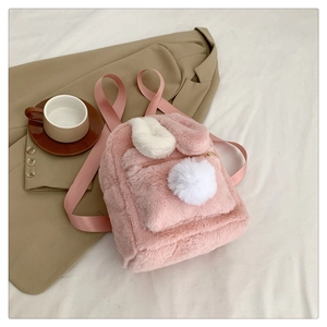 Detail of pink faux fur bunny backpack with soft long ears and white pompom tail charm