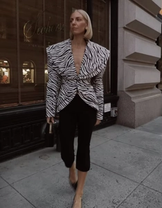 Detailed view of women's zebra print blazer with bold shoulder pads and notch lapels