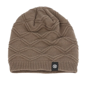 Detail of coffee brown knit beanie with wave texture and circular H logo patch