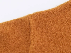 Gros plan sur la texture en maille camel montrant les coutures et la qualité du tissu