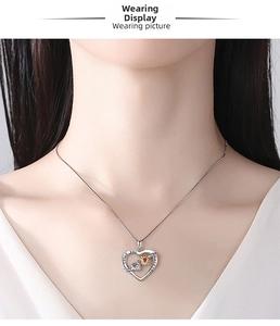 Detail of silver heart necklace with gold sunflower and I love you forever engraving