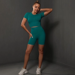 Detail of high-waist teal yoga shorts and seamless crop top in high-stretch fabric