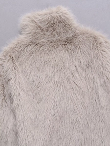 Close-up of high-density faux fur texture on a warm beige chic fashion jacket