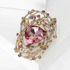 Macro detail of bird nest brooch with pink triangle crystal and colorful rhinestones