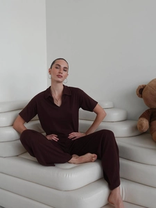 Detail of dark brown knit two-piece set featuring short sleeve V-neck top and wide pants