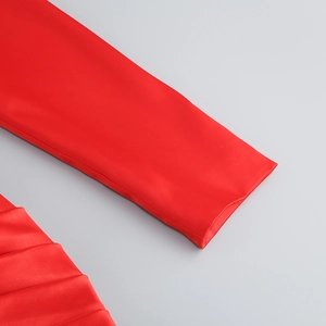 Close-up of bright red bodycon dress showing smooth fabric texture and fine stitching detail