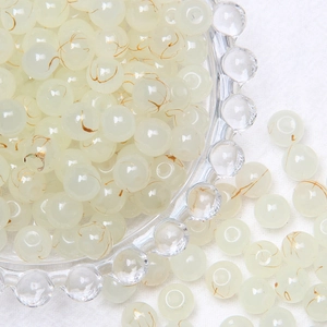Macro detail of 8mm translucent yellow glass beads with gold texture in a glass dish