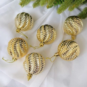 6er-Set goldene Weihnachtskugeln mit Spiralstruktur auf Tannenzweigen und weißem Tüllhintergrund