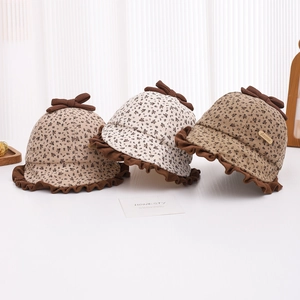 Detail view of baby floral sun hats with brown bows and ruffled edges in three colors