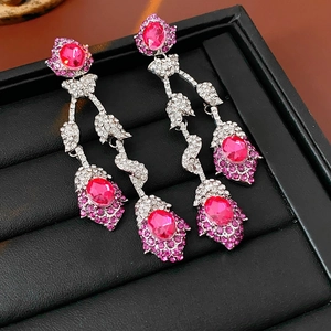 Macro detail of vintage floral tassel earrings with pink oval stones and crystals