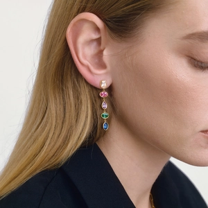 Macro shot of colorful gemstone drop earrings with gold finish on a model