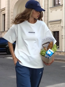 Dettaglio di una t-shirt bianca in cotone con stampa Assertive in stile francese