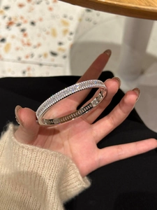 Détail d'un bracelet jonc argenté avec des zircons brillants ronds et de taille baguette