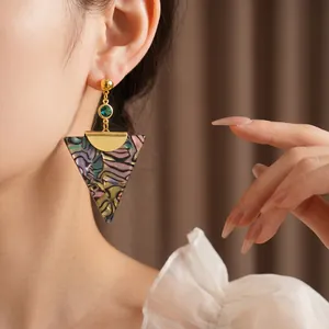 Vintage triangle drop earrings with green gemstone and marble texture on model