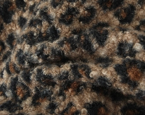Vue macro du tissu léopard en fausse fourrure montrant la texture douce de sherpa bouclé