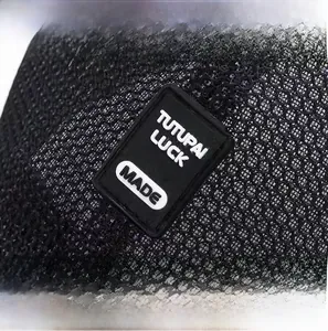 Macro shot of black mesh fabric detail and rectangular rubber logo patch on baseball cap