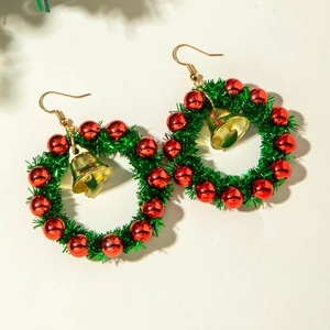 Detailed close-up of festive Christmas wreath earrings with green tinsel and red beads