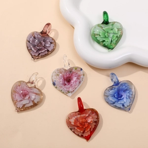 Detailed view of handmade heart-shaped glass pendants with 3D flower patterns inside