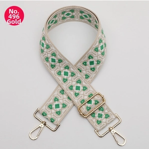 Close-up of green and beige ethnic geometric woven bag strap with golden metal swivel hooks