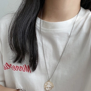 Detail of gold Venus face silhouette pendant on a stainless steel chain for women