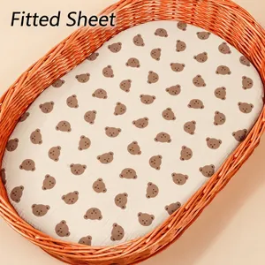 Detail of baby cradle fitted sheet with brown bear prints on soft cotton fabric