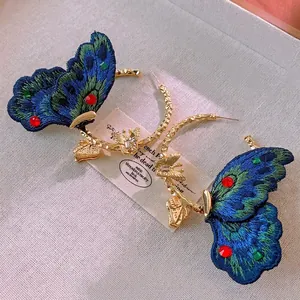 Handcrafted gold butterfly hoop earrings with vibrant embroidery and gemstone accents
