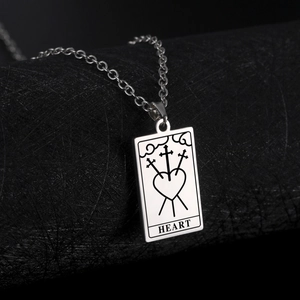 Detailed view of tarot card pendant with three swords heart engraving on steel chain
