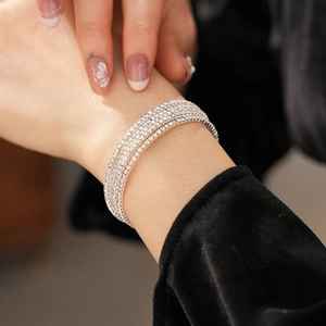 Macro shot of silver multi-layer rhinestone bracelet elegantly layered on a wrist