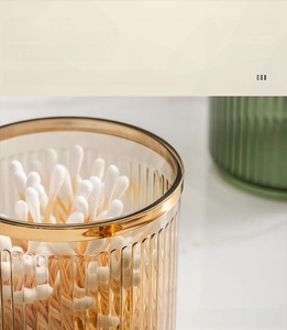 Detail of luxury ribbed glass storage jar with elegant gold rim for cotton swabs