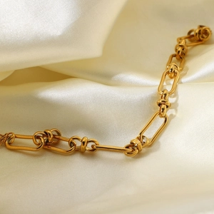 Chunky stainless steel chain bracelet with 18K gold plating on elegant silk fabric