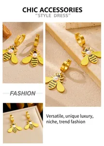 Detail of bee earrings with faux pearls and gold plating on natural stone background