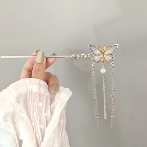 Detailed shot of butterfly tassel hair stick with blue gradient wings and pearl accents