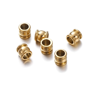 Detailed macro view of gold-plated stainless steel spacer beads with a polished finish