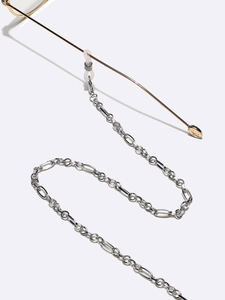 Macro detail of silver Figaro chain eyewear strap with white silicone non-slip loops