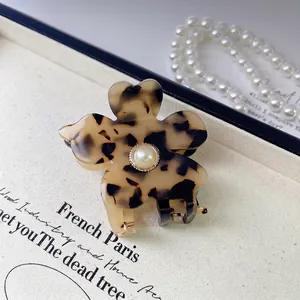 French tortoise shell flower hair claw with white pearl center on vintage display