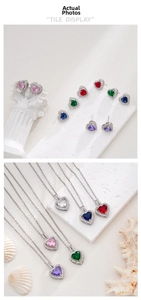 Macro shot of silver heart jewelry set with colorful cubic zirconia on stone background
