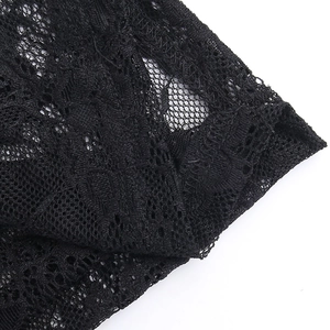 Detailed close-up of intricate black lace fabric with floral embroidery and mesh texture
