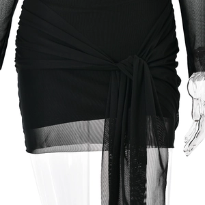 Détail d'une robe noire en tulle avec un nœud à la taille et un ourlet plissé transparent