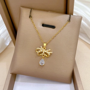 Macro shot of gold-plated butterfly necklace with teardrop zircon in a premium gift box