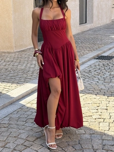 Elegant wine red halter neck maxi dress with waist cinching and high slit on city street