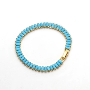 Macro shot of 18K gold plated tennis bracelet featuring square blue turquoise stones