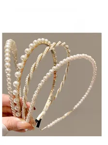 Detail shot of four elegant pearl headbands with golden metal base for young girls