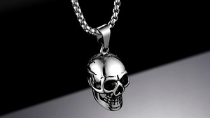 Macro view of silver oversized skull pendant necklace with metallic textures and details