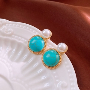 Detail of vintage palace style earrings with round turquoise and white pearl accents