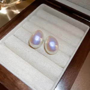 Boucles d'oreilles perles sirène de style français sur un coffret à bijoux en lin beige