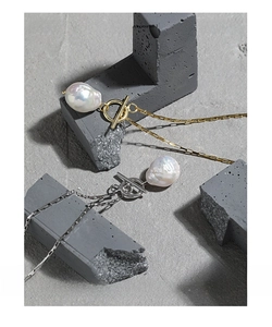 Close-up of Baroque freshwater pearl necklace with OT toggle clasp on grey cement stone