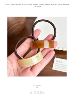 Detail of acetate hair ties with marble texture and France Handmade gold engraving